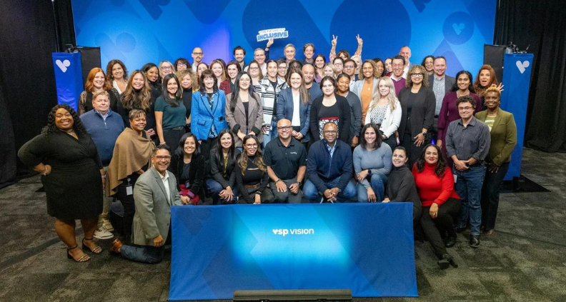 VSP Vision employees posing in front of VSP Vision background celebrating diversity.