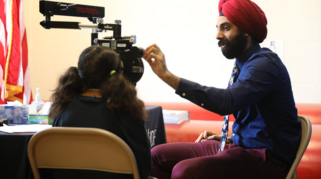 A VSP Vision doctor performing an  eye exam on a girl